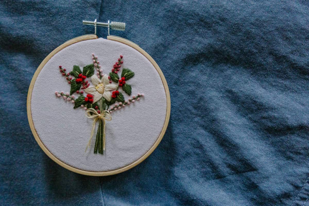 Embroidered December birth flower bouquet with blue background.