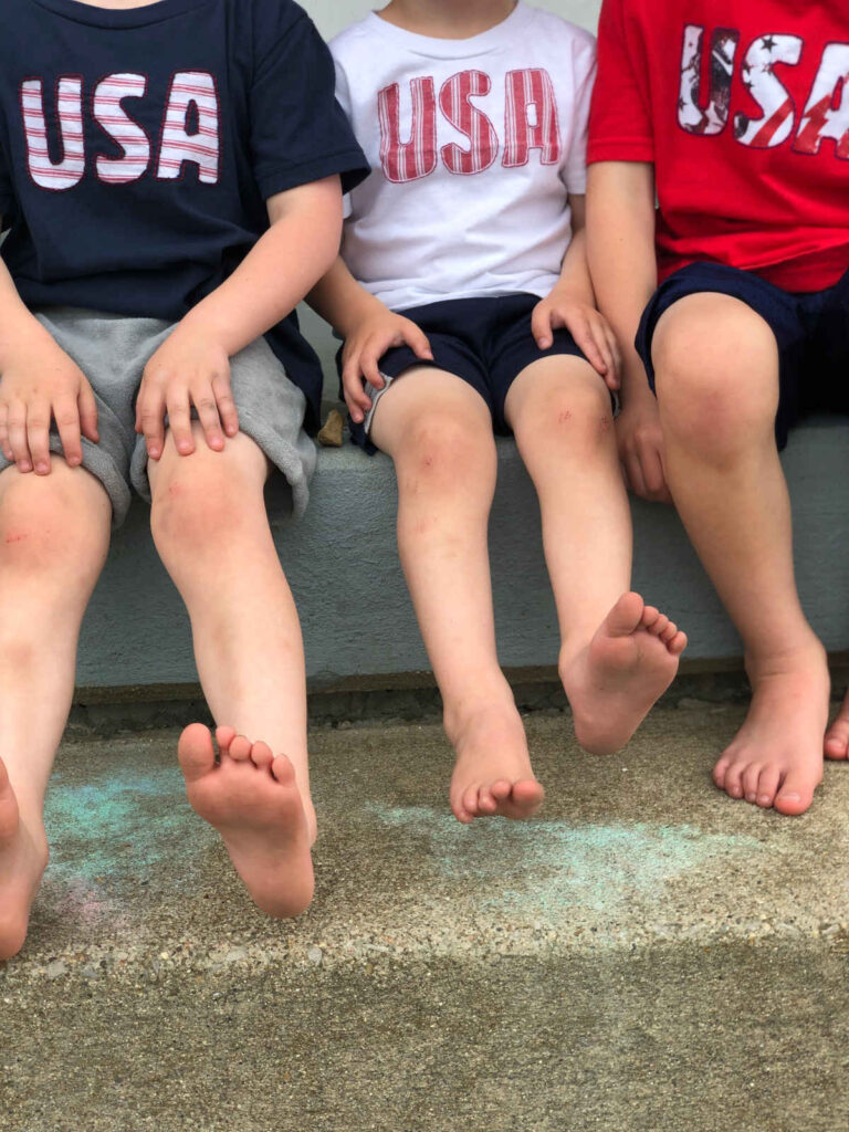 three boys sitting wearing USA reverse applique shirts