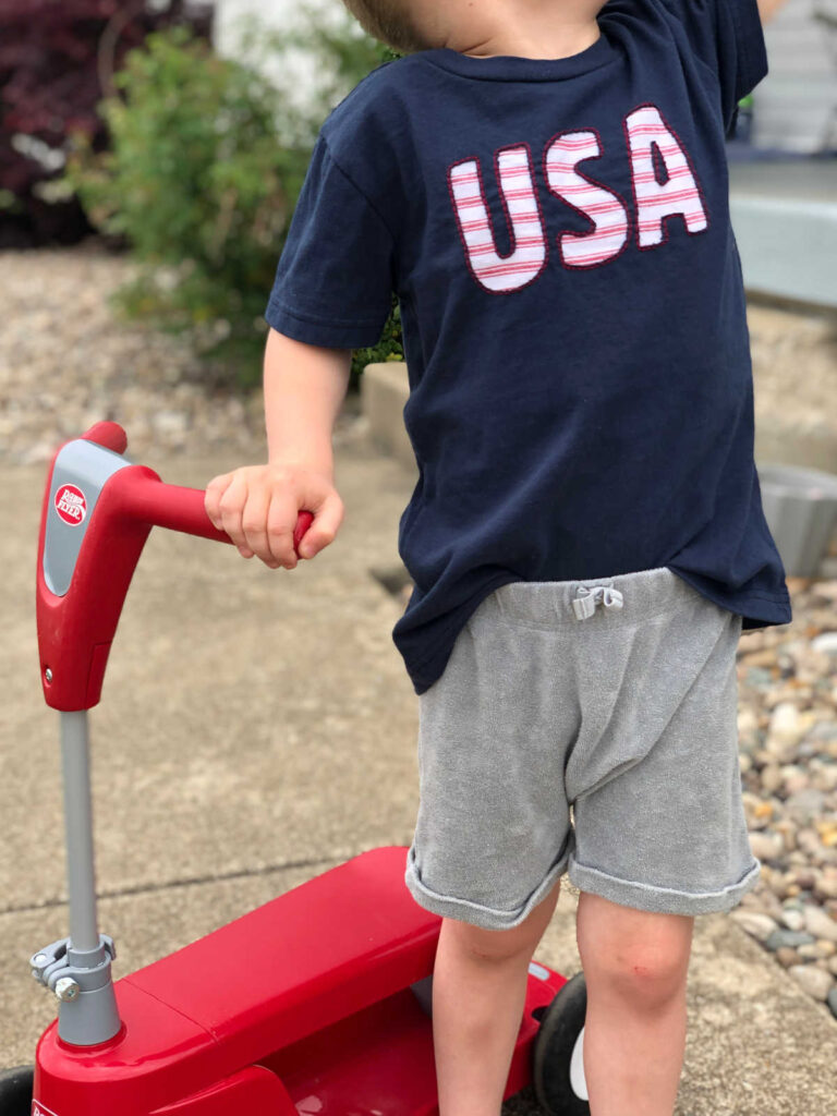 child wearing blue "USA" reverse applique shirt